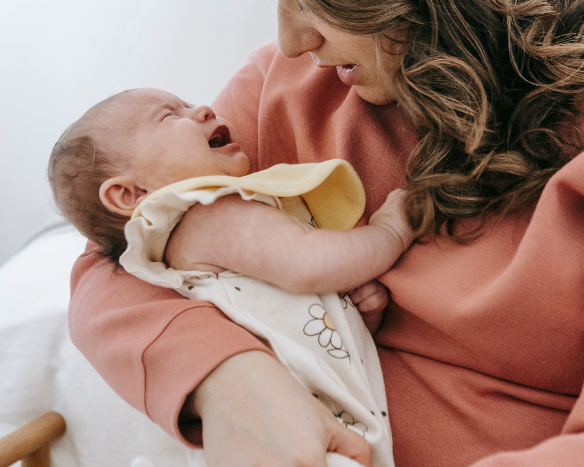 4 Monats Regression: Mutter hält weinendes Baby im Arm 