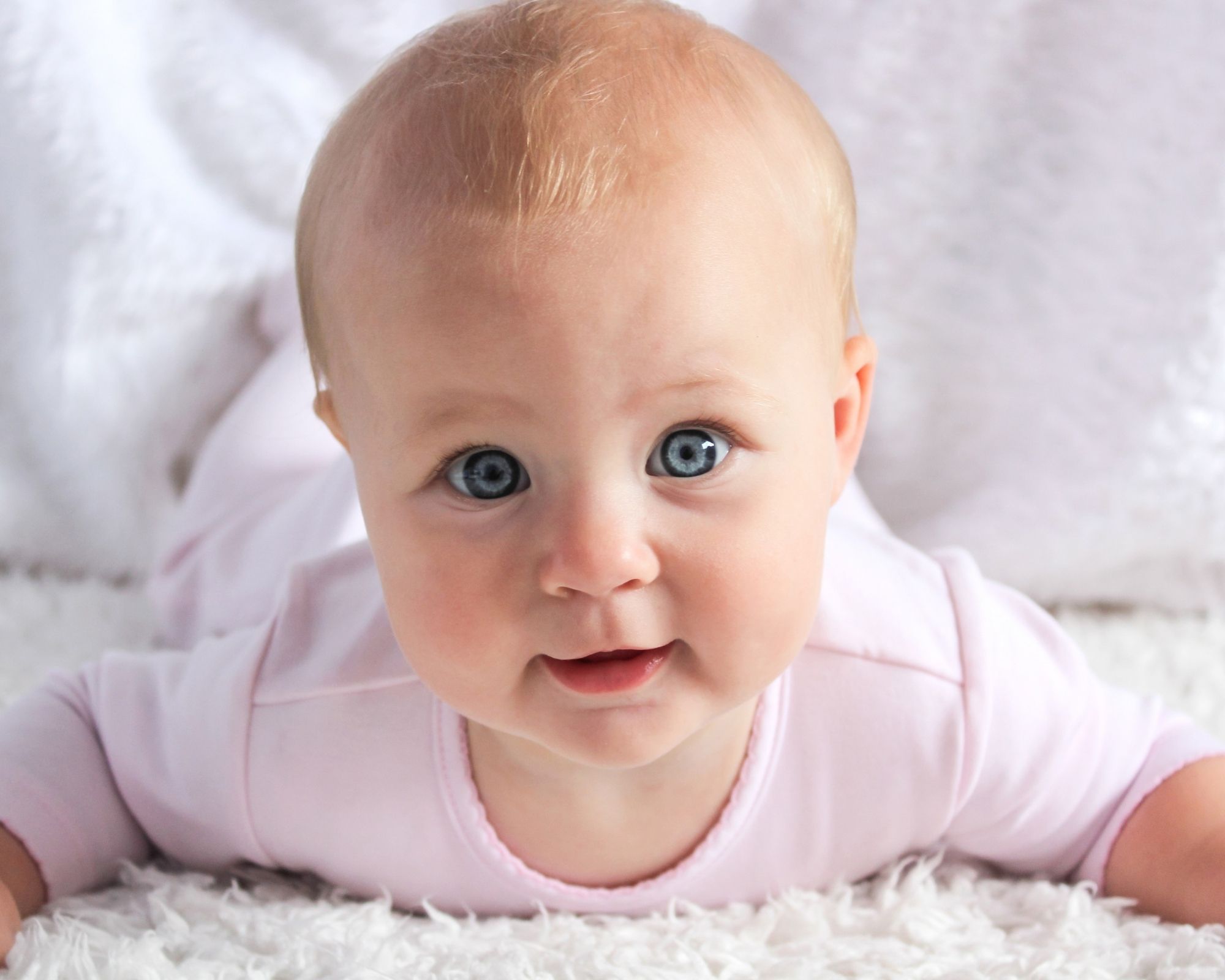 6 Monats Schlafregression: Baby guckt neugierig in die Kamera