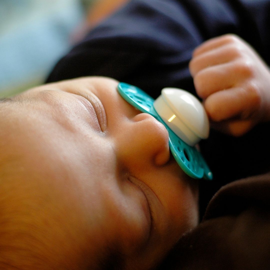 Ein Baby schläft mit einem Schnuller