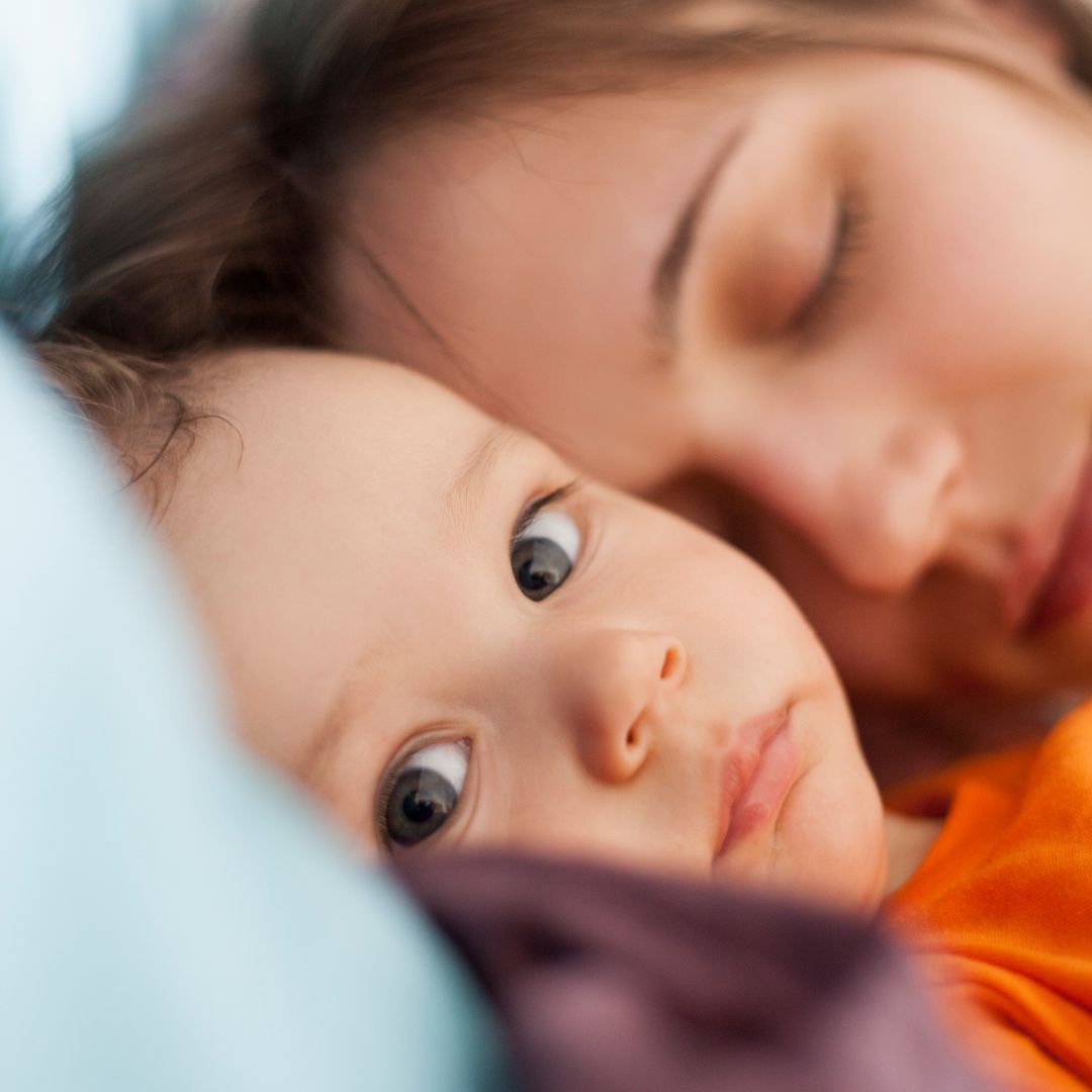 Wachzeit: Baby ist wach und Mama schläft daneben.