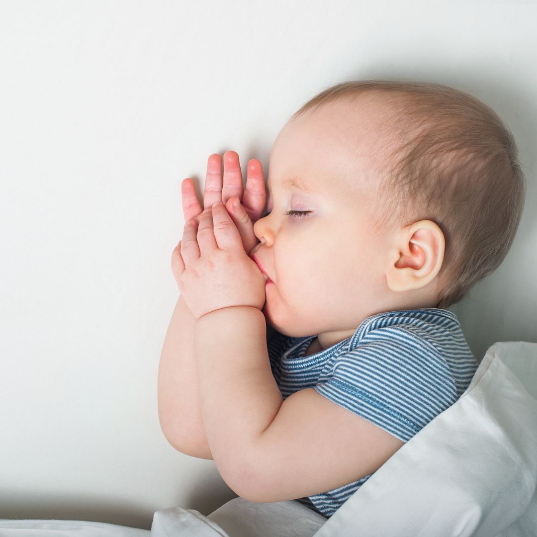 Baby zum Schlafen bringen: Baby schläft und nuckelt am Daumen